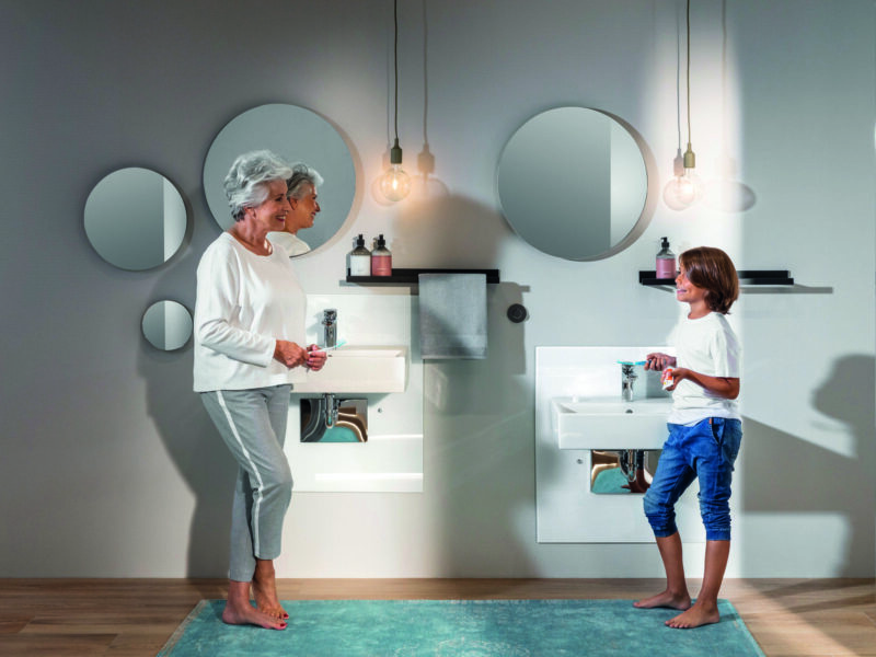 Foto von einem Badezimmer mit einer älteren und jüngeren Person.